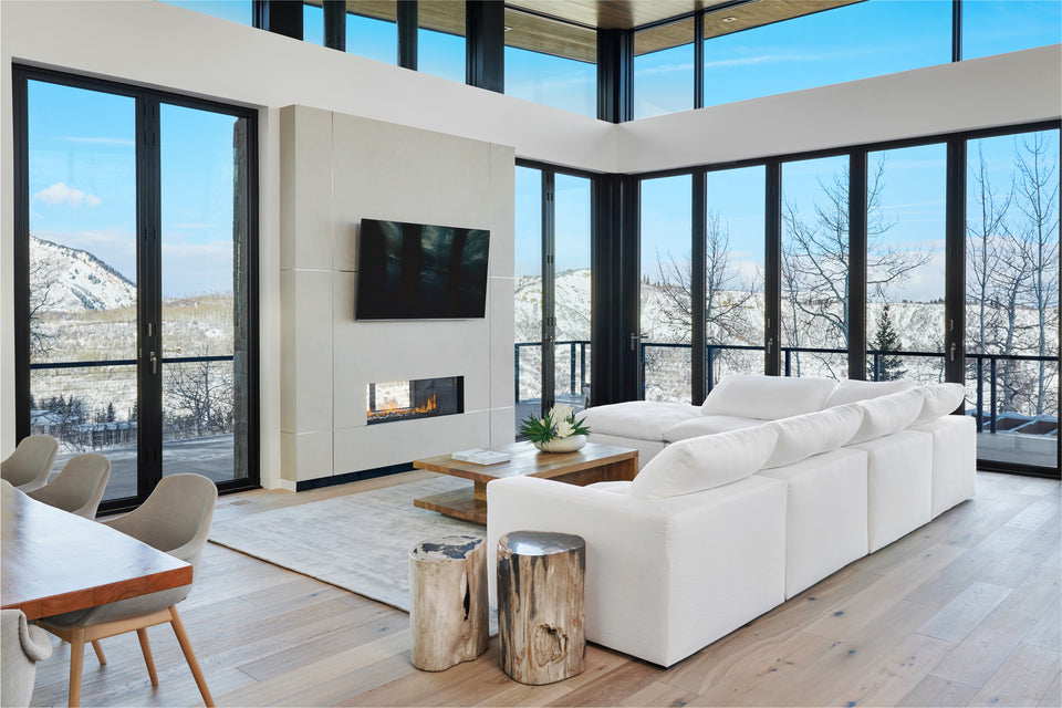 living room with high glass windows and white furniture
