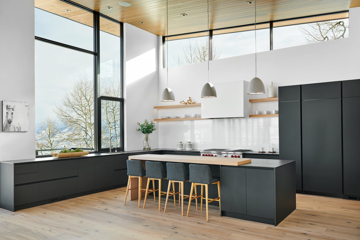 kitchen with black cabinets and island with stools and hanging lamps