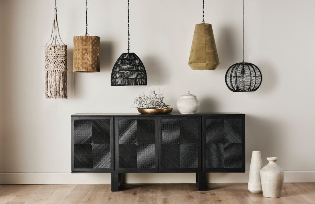 black credenza with hanging decorative lamps against a white wall